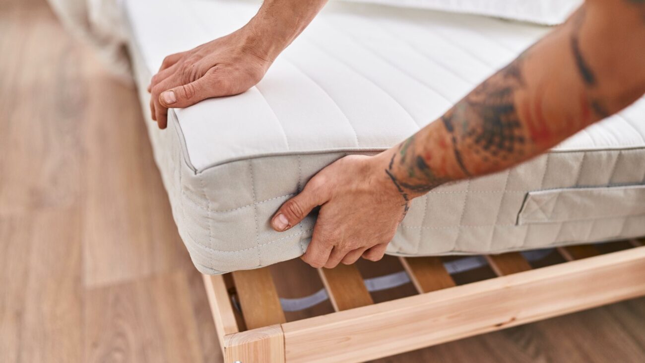 A man is changing the bed mattress